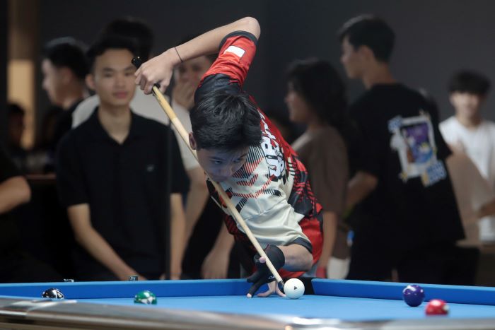 SPORTIF: Peserta turnamen biliar student skuad battle 2024 yang digelar di Surabaya terlihat fokus dalam permainan. (ANDY S/RADAR SURABAYA)