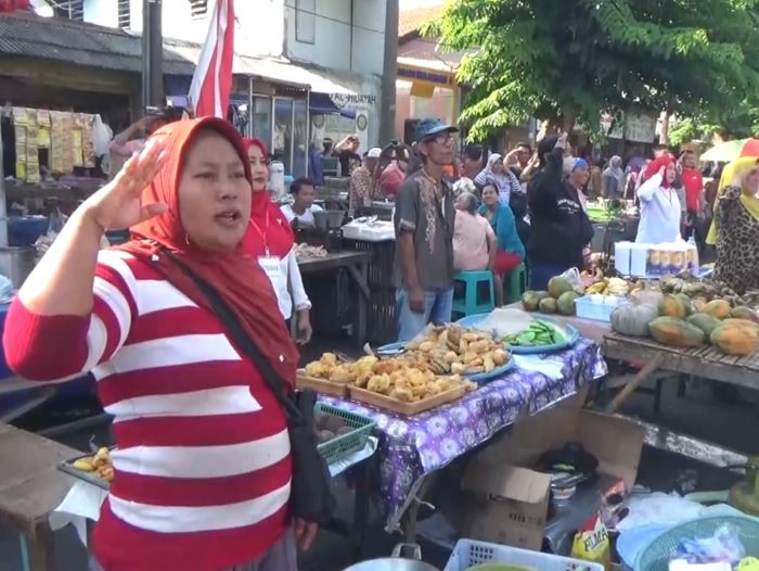 GUGAH NASIONALISME: Para pedagang pasar tumpah Karang Menjangan Surabaya dan warga sekitar menggelar bendera HUT ke-79 Kemerdekaan RI di tepi jalan, Sabtu (17/8). (RAHMAT SUDRAJAT/RADAR SURABAYA)