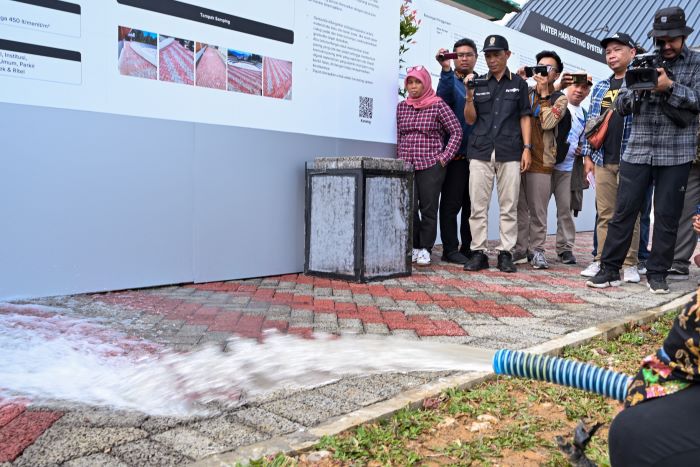UJICOBA: Simulasi penggelontoran air pada solusi beton paving block berpori di area hunian tapak ramah lingkungan SIG di IKN. (IST)