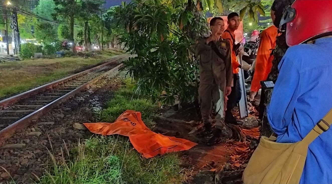 NAHAS : Petugas mengevakuasi mayat pria tanpa identitas yang tertabrak KA di perlintasan Jalan Ahmad Yani depan SMKN 3 Surabaya ke RSUD dr Soetomo.