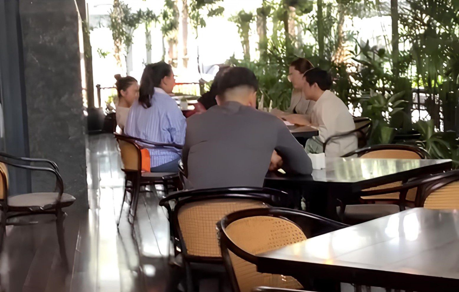 Azizah berbaju biru muda dengan rambut dikuncir tampak sedang berada di Hotel Langham