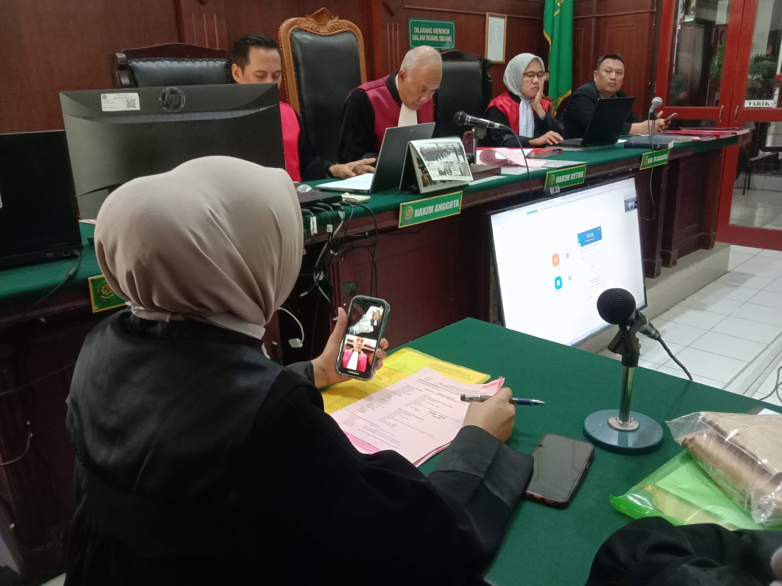 DIADILI: FAJAR/RADAR SURABAYA  DIADILI : Para terdakwa secara daring mendengarkan dakwaan jaksa di PN Surabaya.