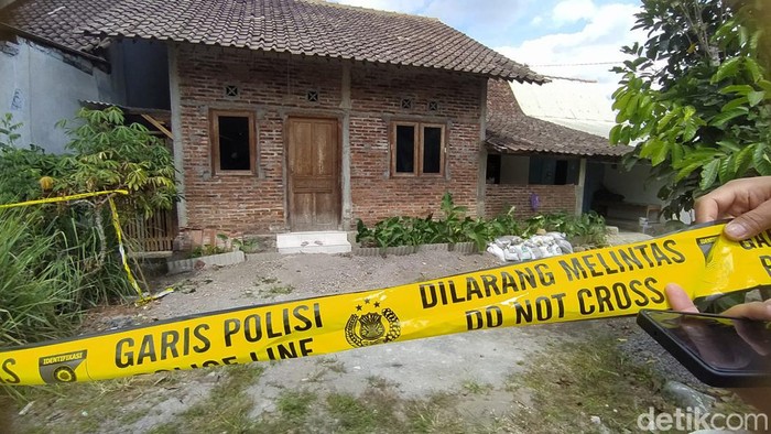 MAKAN KORBAN: Petugas memasang garis polisi di rumah yang diduga untuk mengoplos miras di Paremono, Mungkid, Magelang.