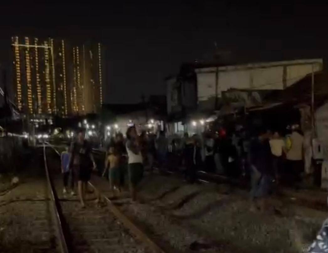 Petugas dan warga sekitar rel Jalan Dupak Rukun, Surabaya, saat evakuasi jasad korban yang tertabrak KA. Tubuh korban dalam kondisi hancur. (IST)