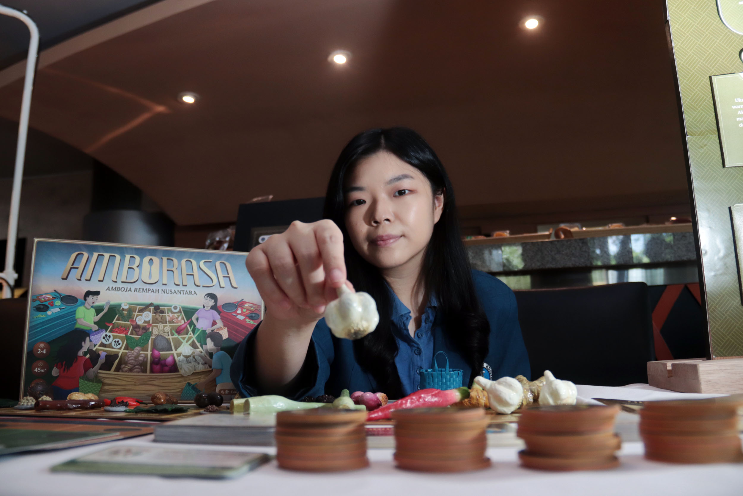 GAME EDUKASI: Mahasiswa Desain Komunikasi Visual Petra Christian Universirty Surabaya, Fiorella Chelsea menunjukkan permainan buatannya, board game Amborasa.