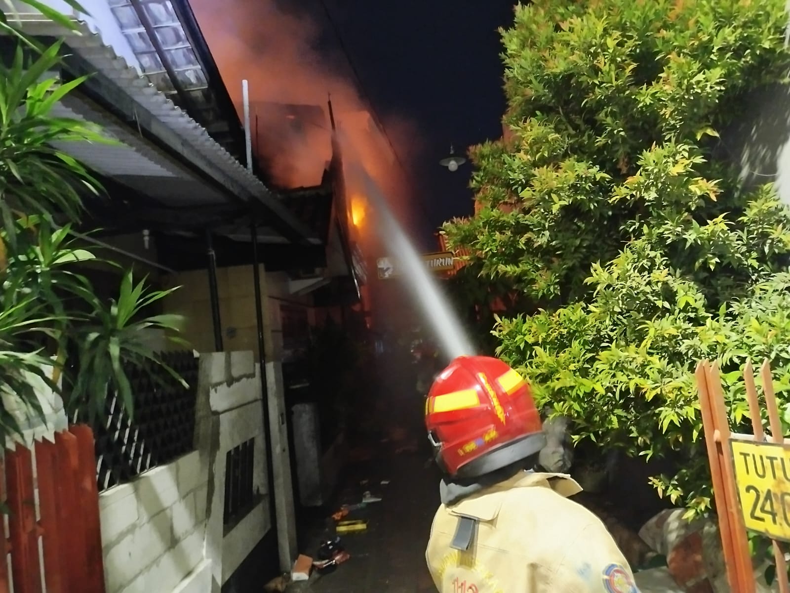 Rumah di Kupang Krajan Surabaya terbakar. Petugas melakukan pemadaman api. (IST)