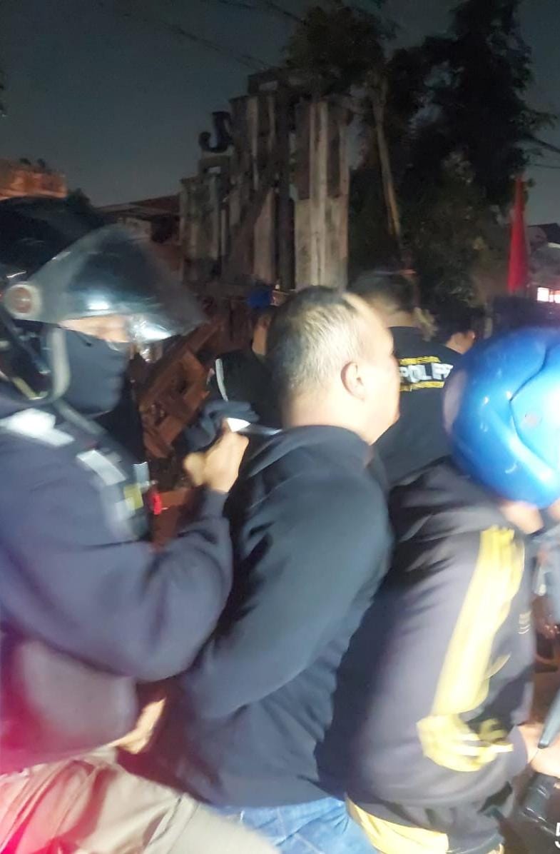 KABUR: Satu dari pria (tengah) yang diamankan petugas saat melintas di Jalan Nias Surabaya.