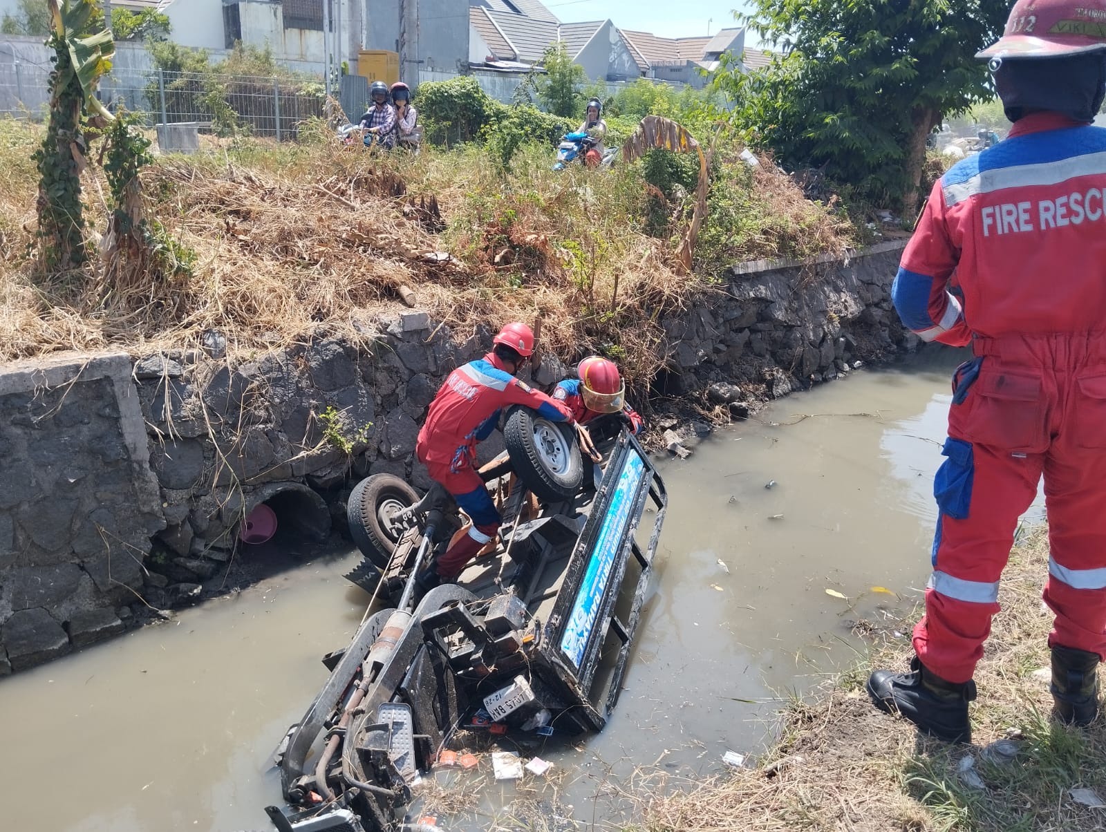 Petugas mengevakuasi tossa yang tercebur sungai di Gunung Anyar Surabaya. (IST)