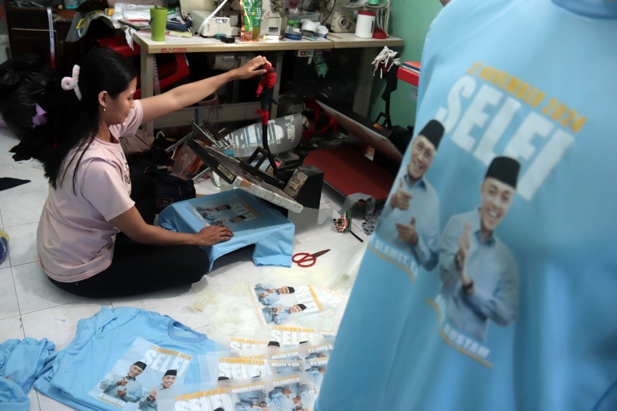 KAOS PILKADA: Pekerja menyablon kaos dengan gambar salah satu peserta Pilkada 2024, di salah satu usaha konveksi di Surabaya, Kamis (12/9).