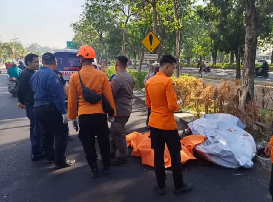 TRAGIS : Petugas mengevakuasi mayat korban Adjie Ramadhan untuk dibawa ke rumah sakit.