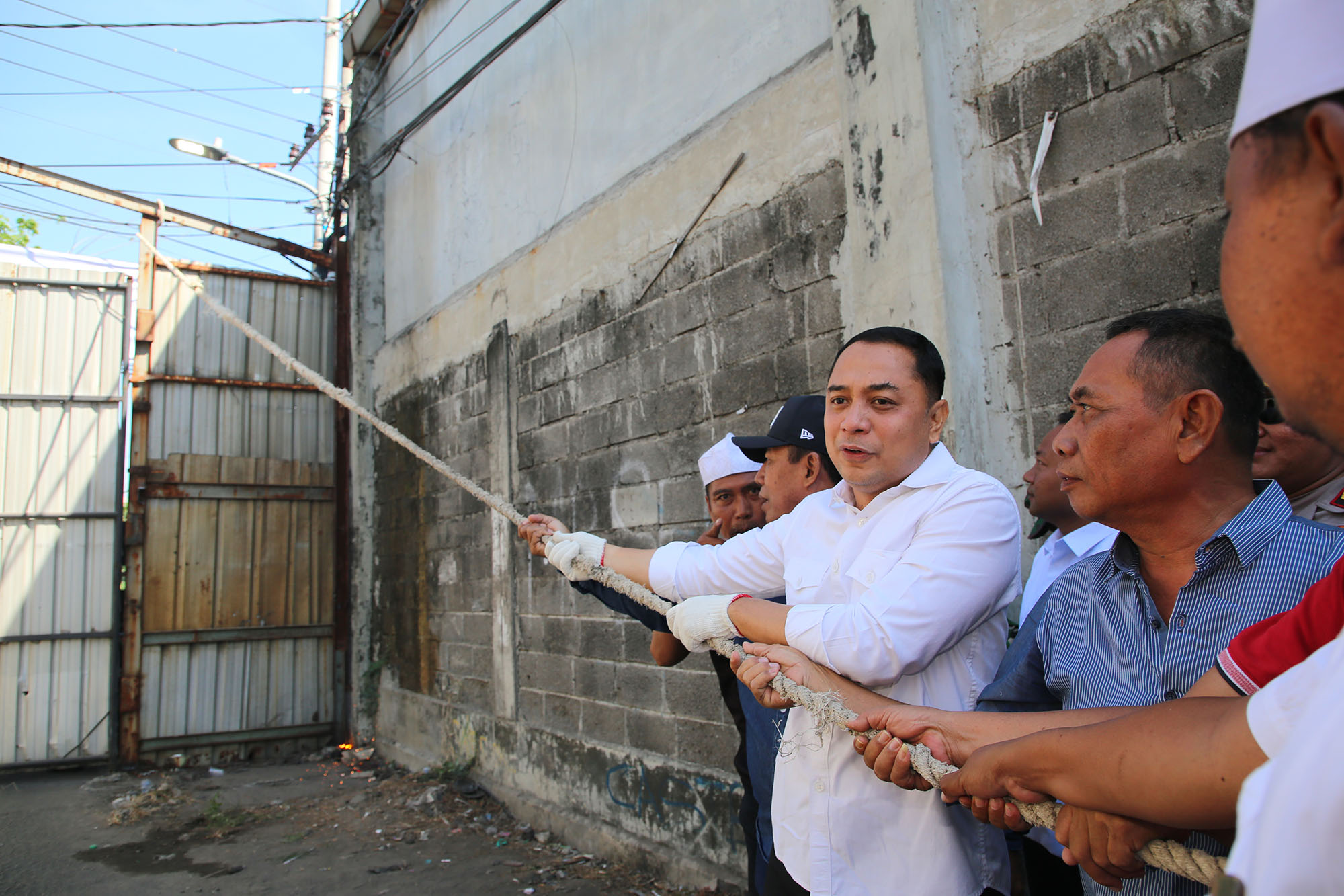 Eri Cahyadi bersama warga dan pemilik lahan Masud (kanan) membongkar tembok yang bertahun tahun membuntu Jalan Tambak Wedi Baru.