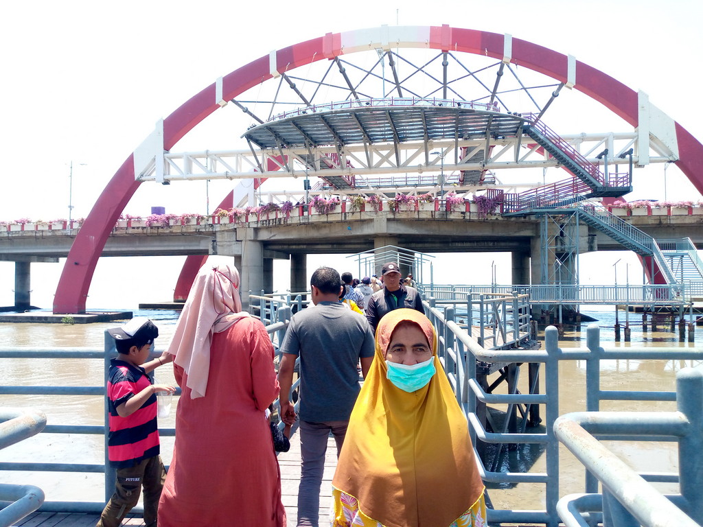 Pengunjung dari luar kota pun ikut menikmati wisata Pantai Kenjeran Surabaya dengan view Jembatan Suroboyo.  (LAMBERTUS HUREK)