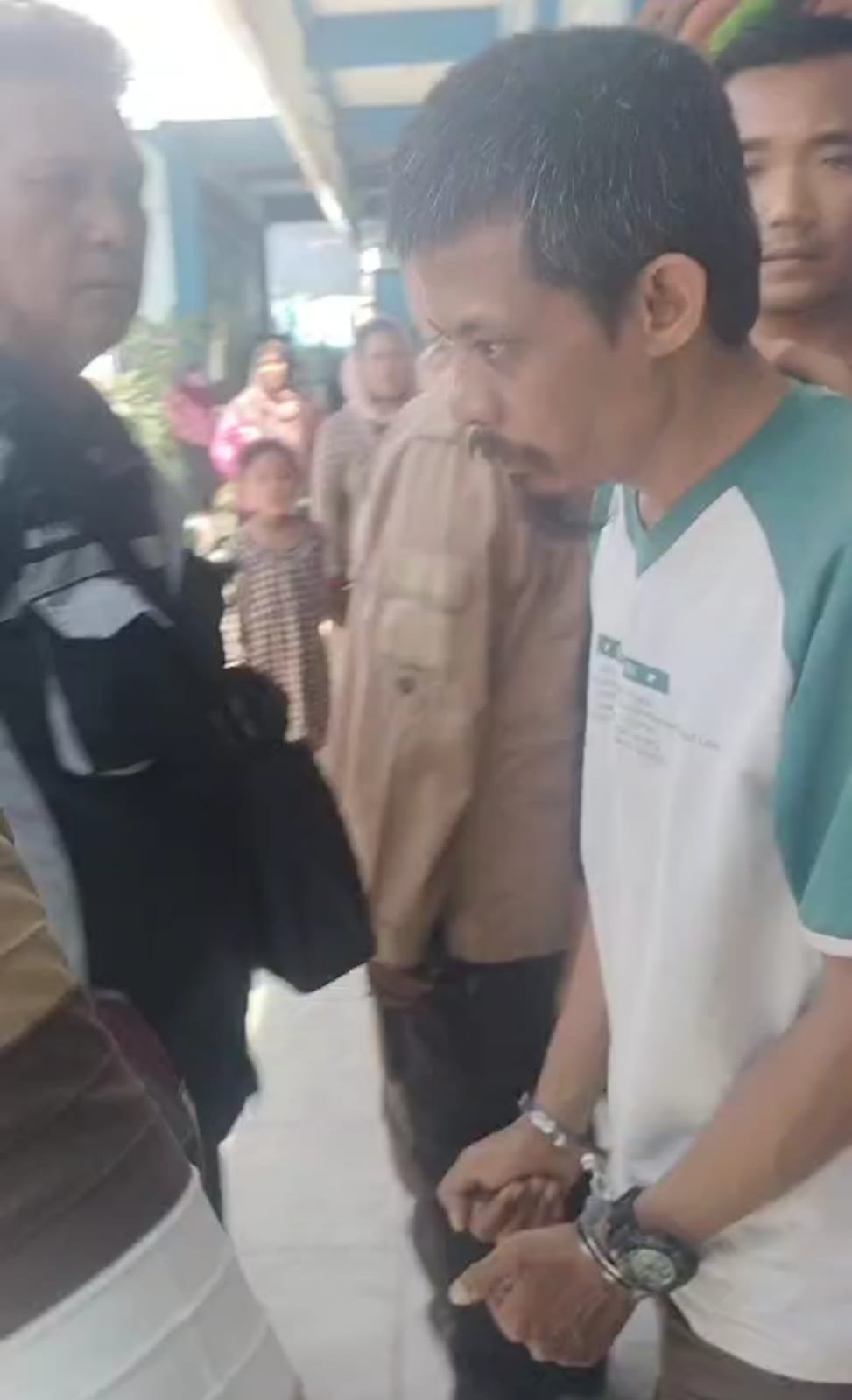 Oknum pembina pramuka berinisial Z saat dijemput di SD tempatnya mengajar. Ia melakukan pencabulan terhadap siswinya ketika kegiatan kemah di sekolah. (IST)