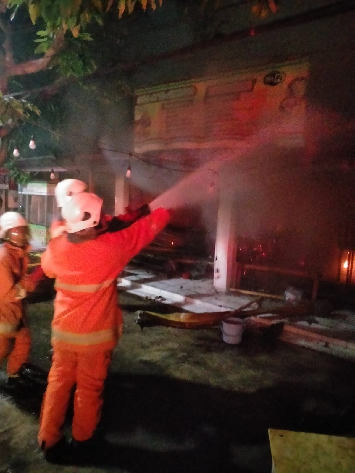 Petugas DPKP Surabaya berusaha memadamkan api yang membakar dua kios warung di Jalan Raya Lidah Wetan, Surabaya, Selasa (17/9). (IST)
