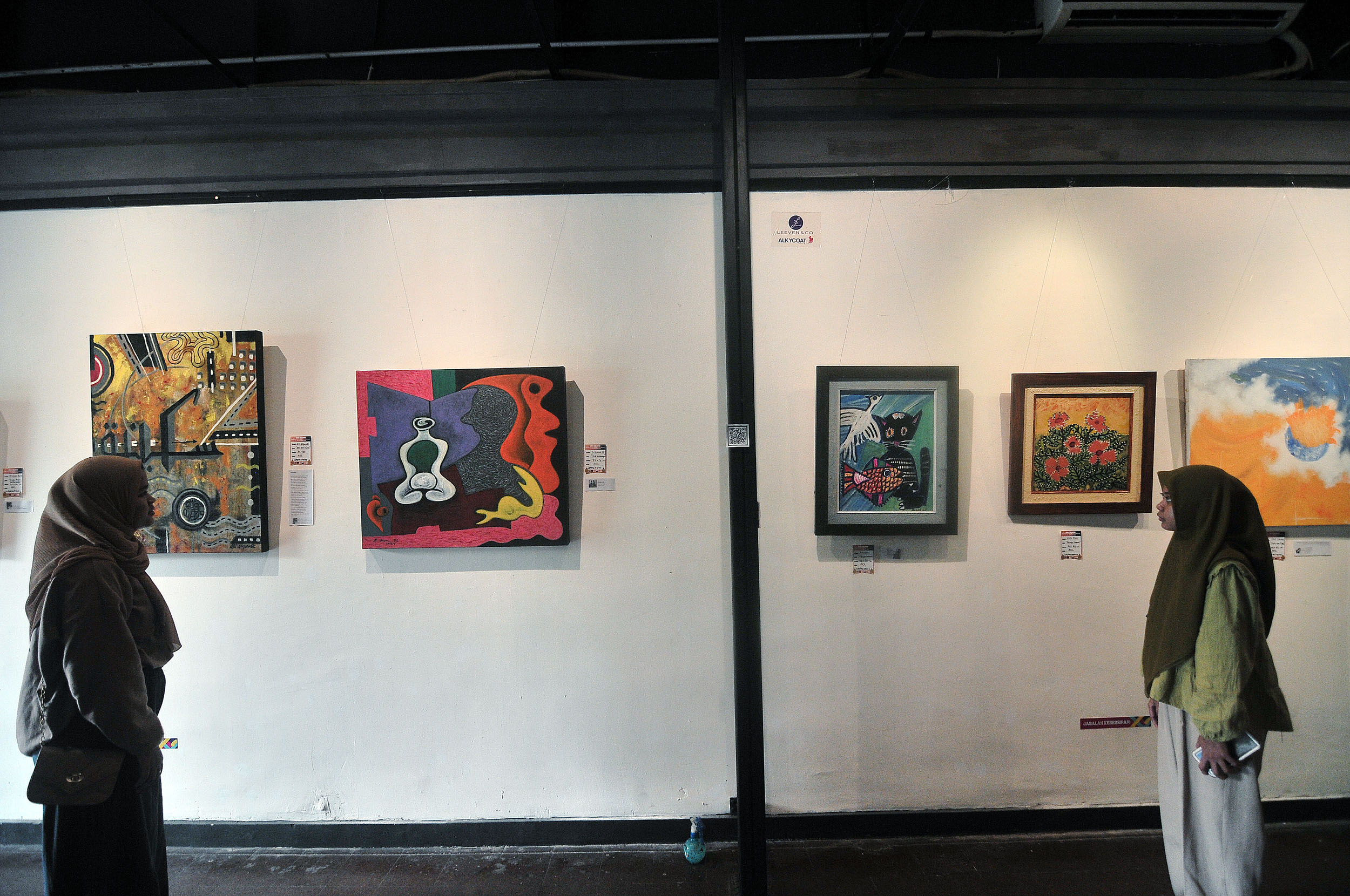 Pengunjung mengamati lukisan karya perupa lintas generasi dalam pameran lukisan bertajuk Hong Wilaheng Sekaring Bawana Langgeng di Galeri Dewan Kesenian Surabaya, Selasa (17/9).