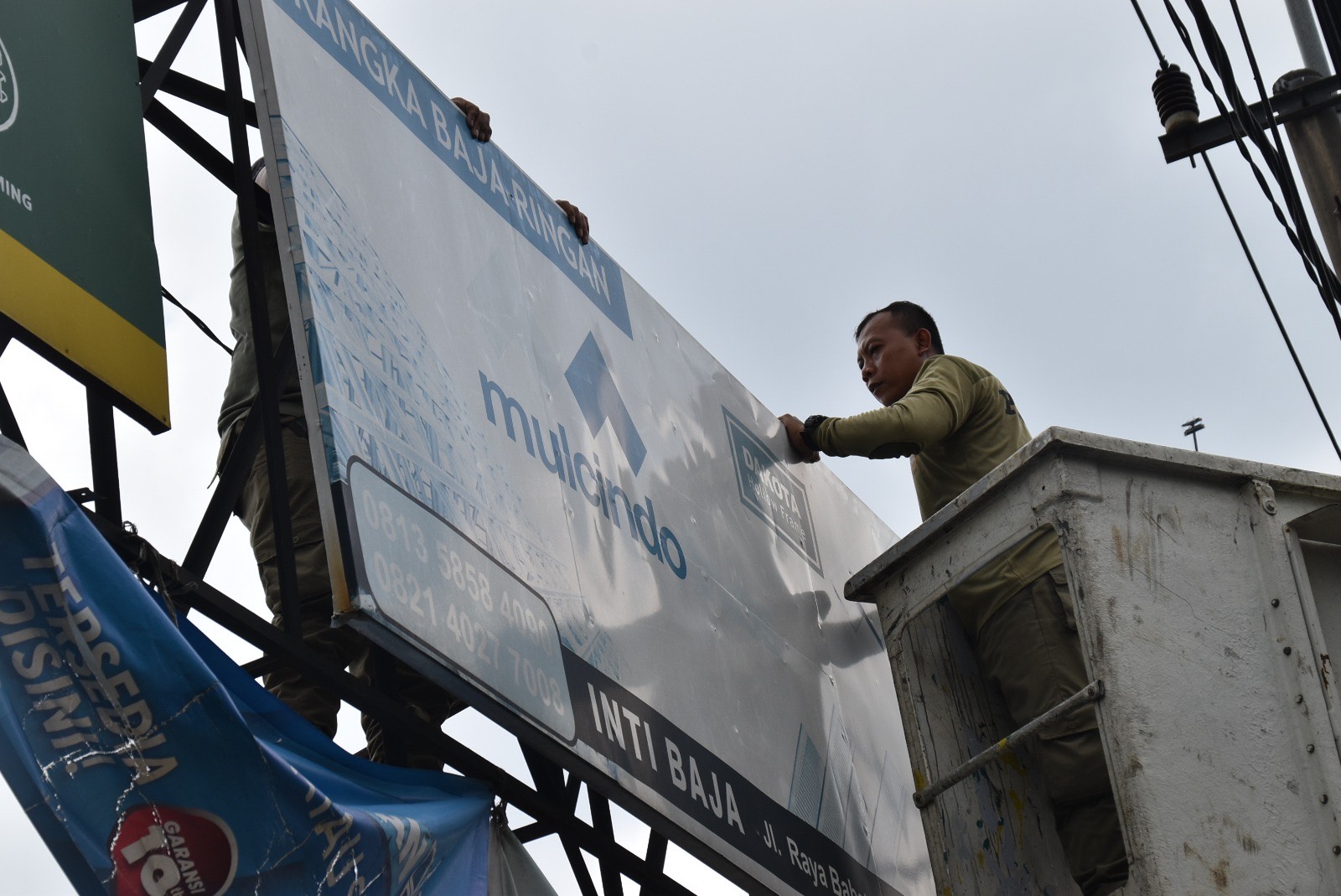 Satpol PP Kota Surabaya saat melakukan penertiban terhadap penyelenggaraan reklame tak berizin dan tidak membayar pajak, Senin (19/2/2024).