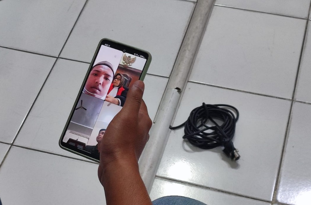 NGAKU: Terdakwa Moch Mawardi saat mendengarkan keterangan saksi di PN Surabaya melalui sidang daring.