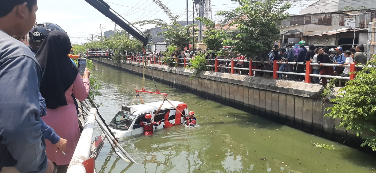 NAHAS: Petugas mengevakuasi Wirawiri Suroboyo nopol L 1318 UUC yang dikemudikan Hendro Puji Laksono, 70 yang tercebur di sungai Jalan Medokan Sawah, Rungkut Surabaya, Kamis (19/9)