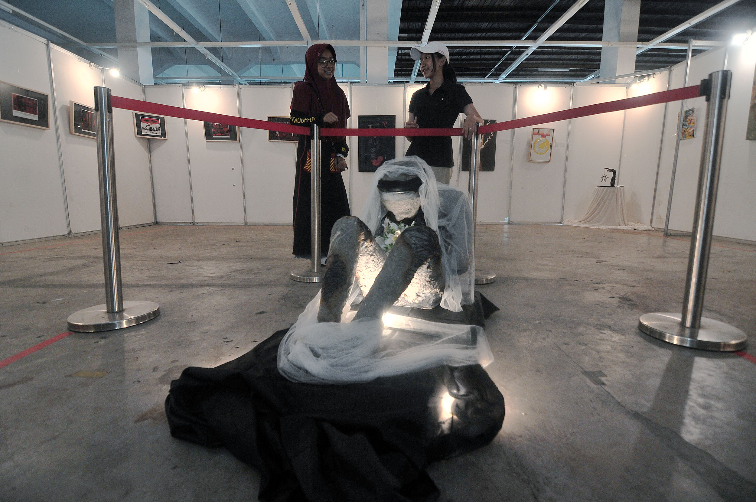 PENUH MAKNA: Pengunjung mengamati salah satu karya instalasi seniman yang dipamerkan dalam Art Show and Exhibiton di AJBS Home Center Surabaya, Minggu (22/9).