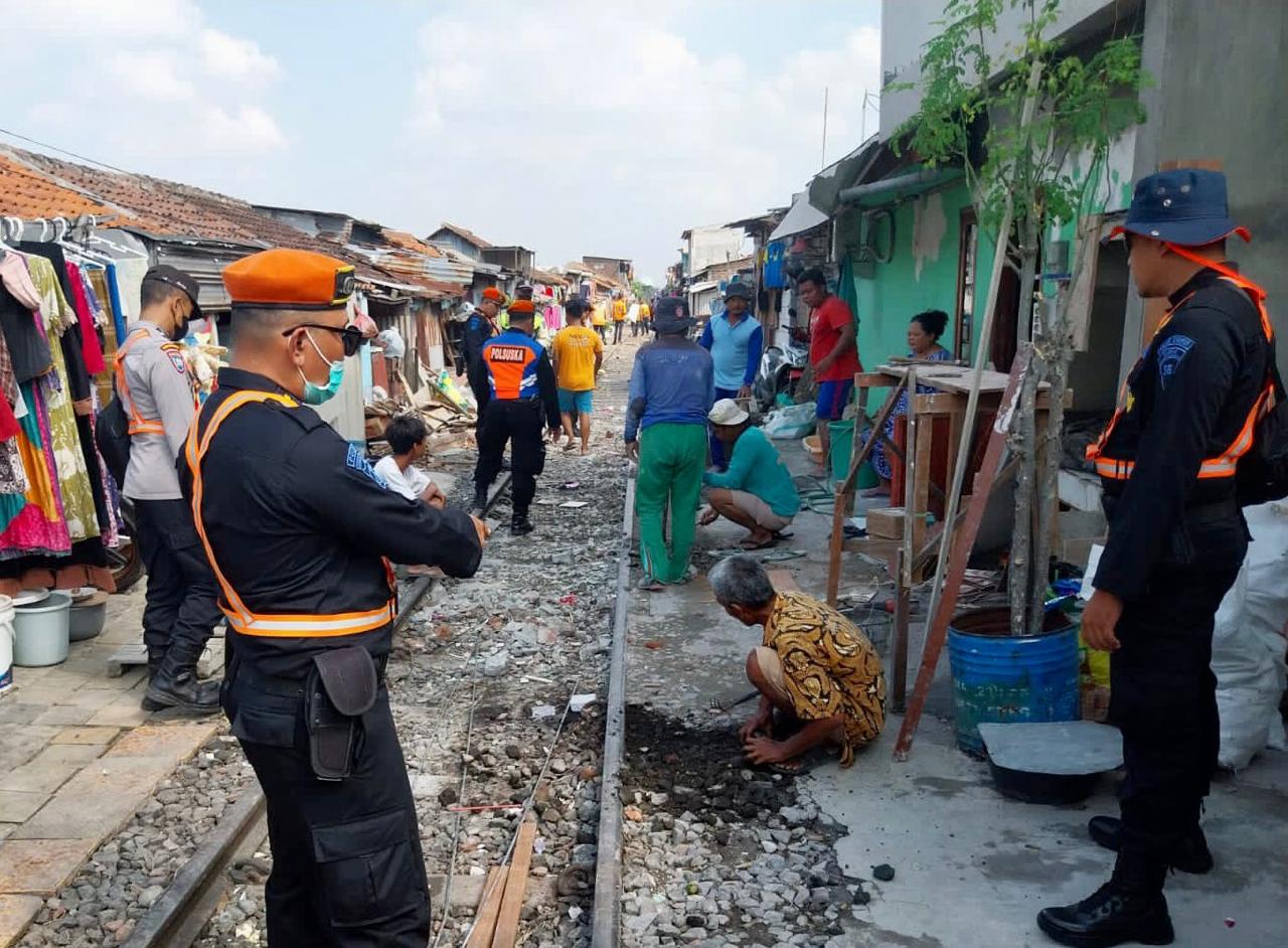 WASPADA: Petugas KAI Daop 8 Surabaya melakukan imbauan ke masyarakat yang beraktivitas di jalur maupun di tepi jalur KA di kawasan Surabaya.