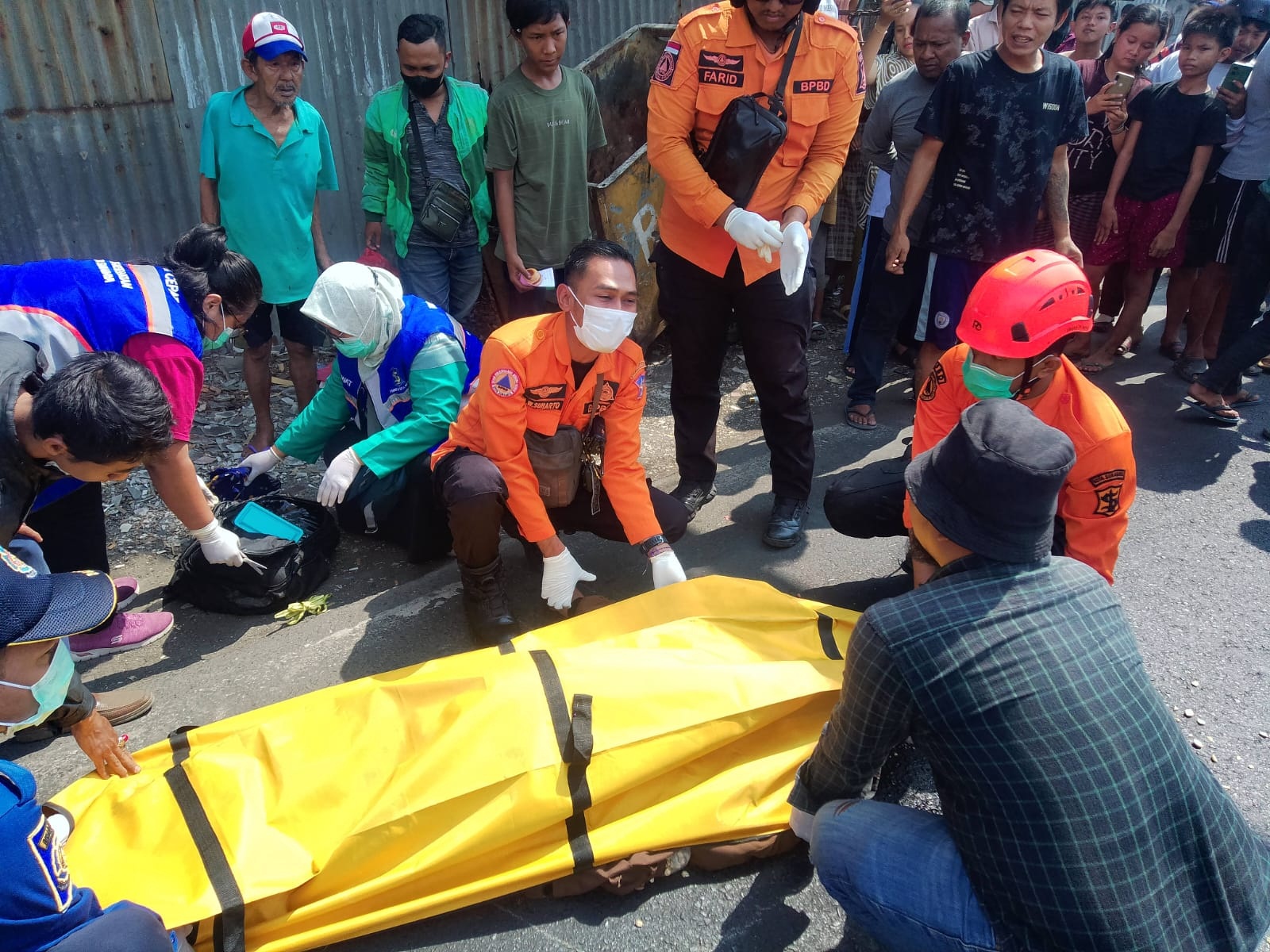 Petugas mengevakuasi jenazah korban kecelakaan di Jalan Kalianak Timur, Surabaya. Korban Muhayin meninggal dunia seusai terlibat kecelakaan antara sepeda motor dan truk. (IST)