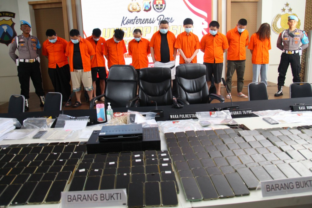 Petugas menunjukkan barang bukti dan tersangka kasus scamming yang berhasil diamankan di Mapolrestabes Surabaya.