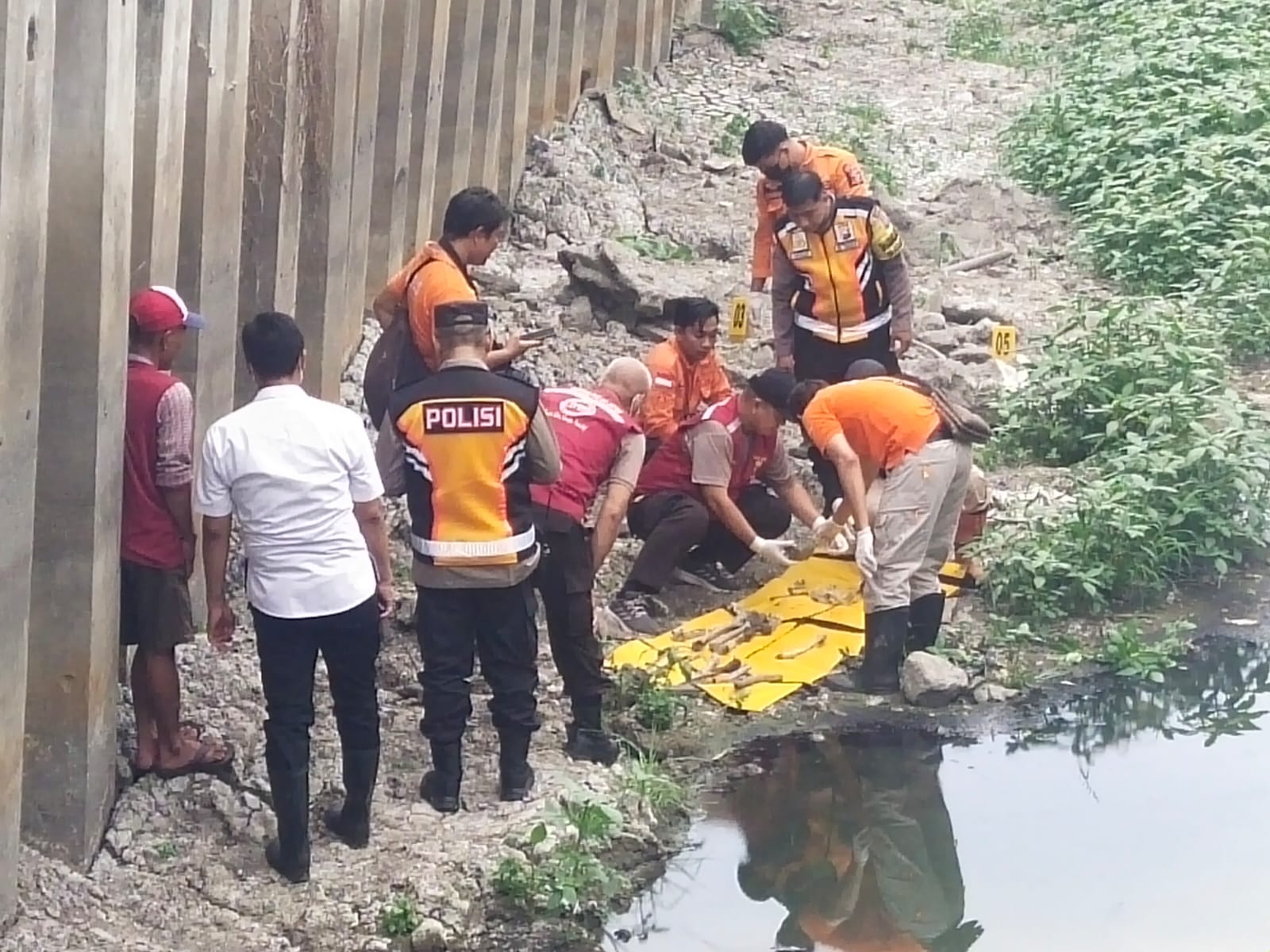 Petugas mengumpulkan kerangka manusia yang ditemukan di kawasan Kedung Baruk, Surabaya. (IST)