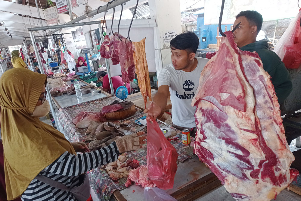 Pedagang melayani pembeli daging sapi di Pasar Daging Arimbi, Surabaya.