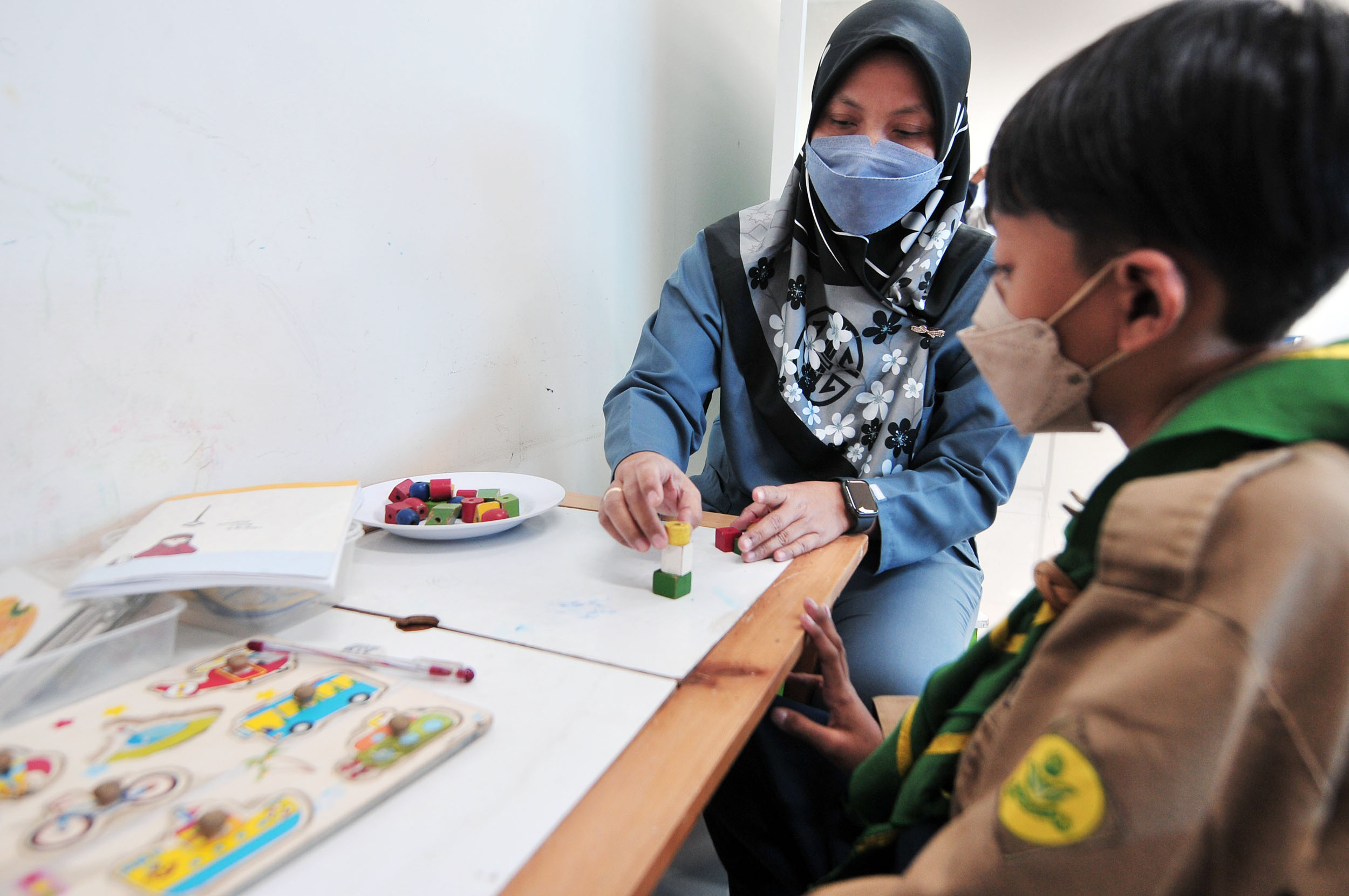 TERAPI: Seorang anak saat mendapatkan terapi di Poli Jiwa dan Remaja RSJ Menur Surabaya. Terapi seperti menulis bisa merangsang psikomotorik si anak dari pengaruh gadget.