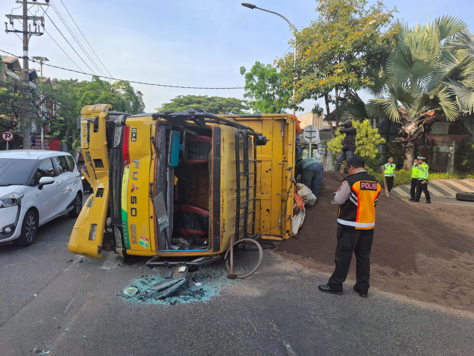 Kondisi dump truk muatan sirtu terguling di Jalan Ngagel, Surabaya, Jumat (4/10) pagi. (IST)