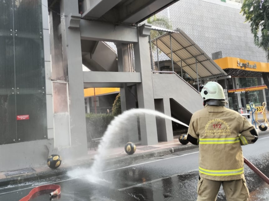 TERBAKAR: Petugas Damkar berusaha memadamkan lebakaran lift JPO di Jalan Pemuda, Surabaya, yang sempat membuat panik masyarakat sekitar.
