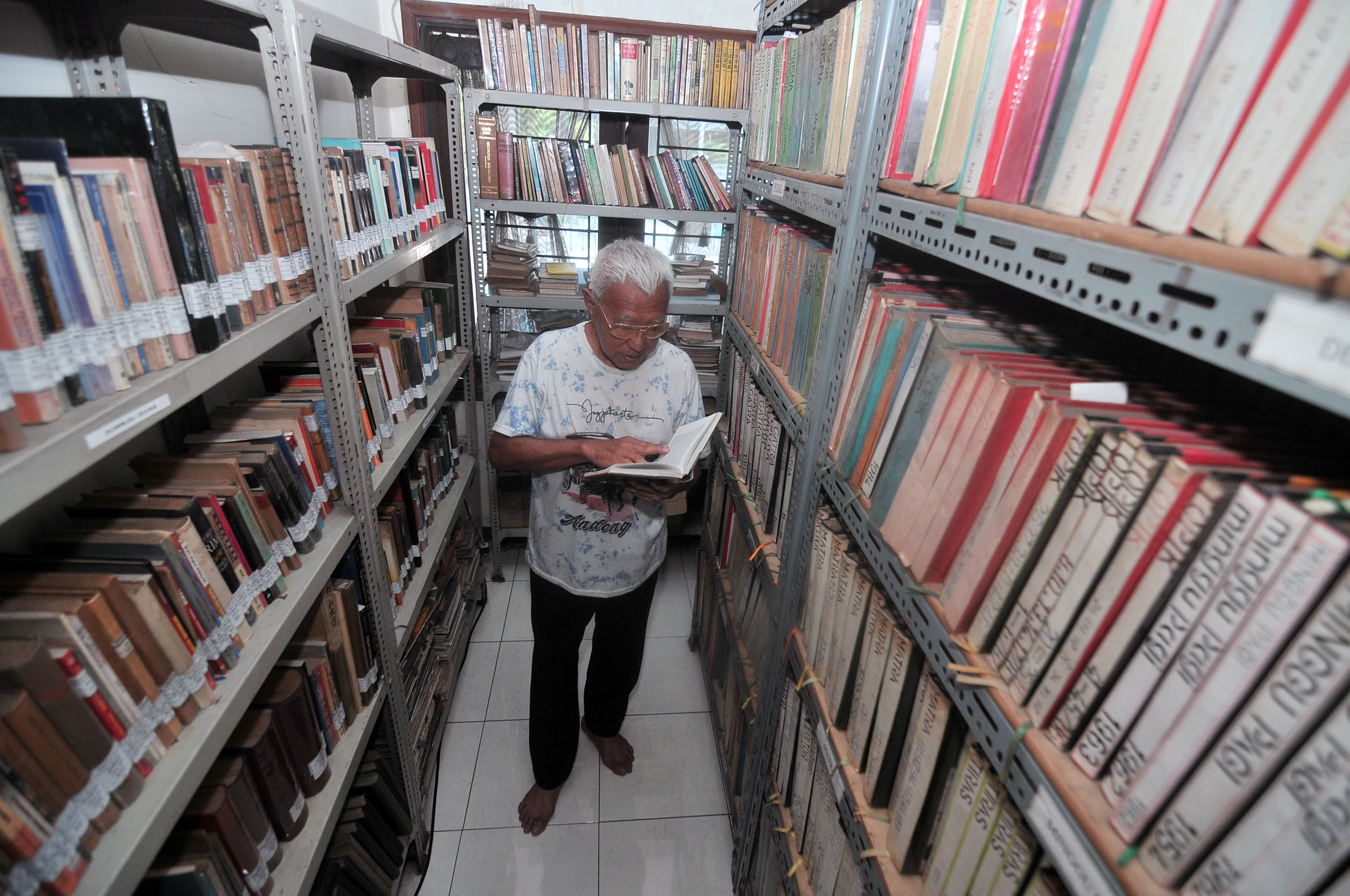 PULUHAN RIBU KOLEKSI: Ketua Yayasan Perpustakaan Medayu Agung Surabaya, King Gaudi menunjukkan beberapa buku koleksi perpustakaan pribadi yang dikelolanya, Senin (7/10).