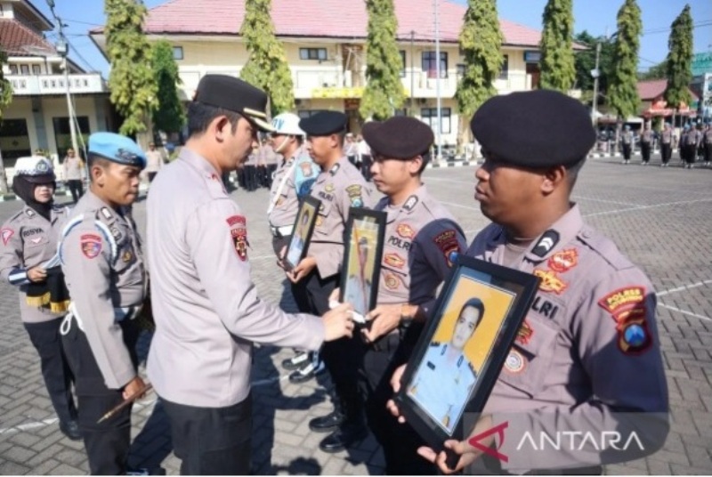 SIMBOLIS: Kapolres Situbondo AKBP Rezi Dharmawan mencoret foto personil kepolisian yang di-PTDH karena desersi dan terlibat penyalahgunaan narkoba.