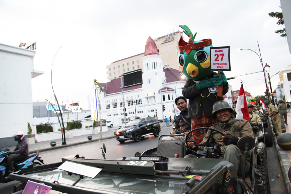 DIARAK: Maskot Pilkada Surabaya dan Pilkada Jatim saat diarak di Jalan Rajawali, Surabaya.