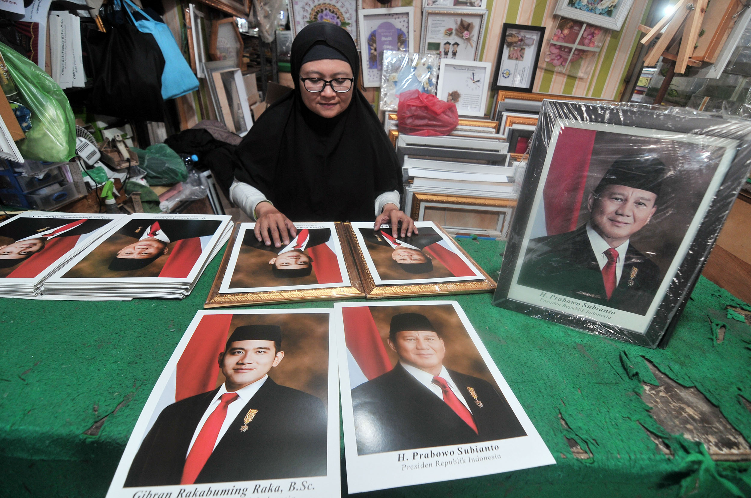 PRESIDEN TERPILIH: Bimbi Sushadiyati, penjual bingkai dan foto pasangan Presiden dan wakil Presiden Indonesia terpilih, Prabowo Subianto dan Gibran Rakabuming Raka di Pasar Blauran, Surabaya.