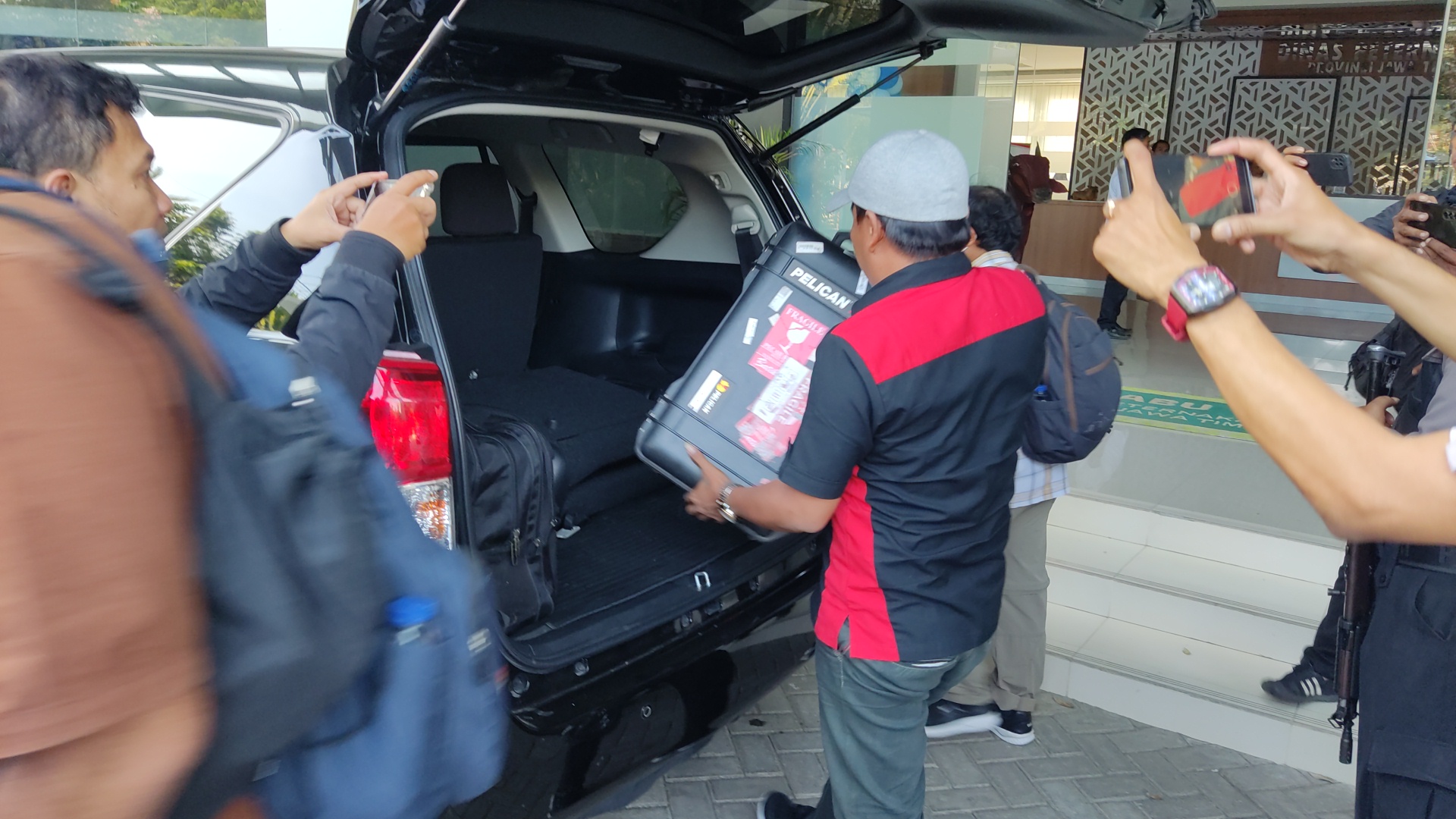 Usai melakukan penggeledahan di Kantor Dinas Peternakan Jatim, petugas KPK membawa berkas-berkas dalam koper dan ransel.