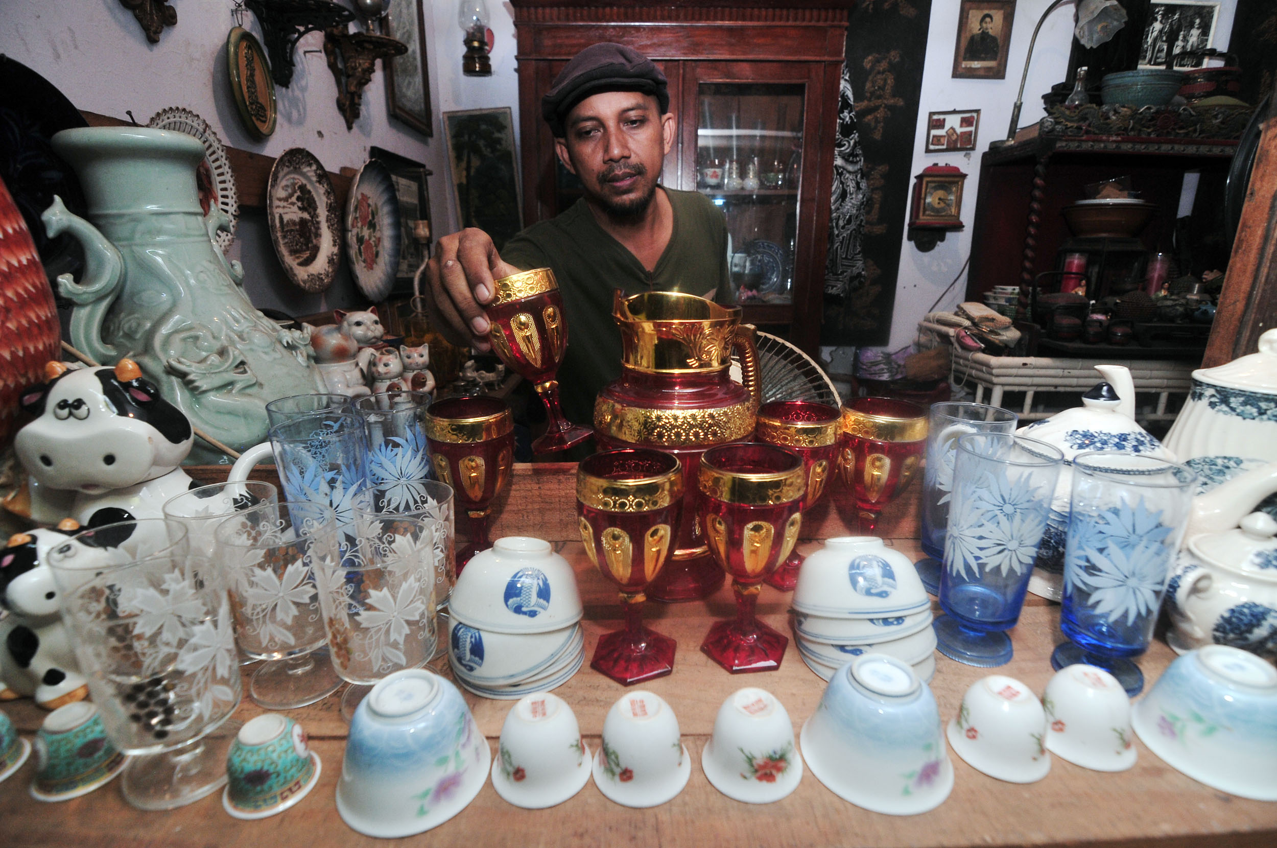 BARANG JADUL: Marsidi, pemilik toko Joyo Chotdeng Vintage merapikan barang pecah belah koleksinya di Pasar Nostalgia Bratang, Surabaya, Kamis (17/10).