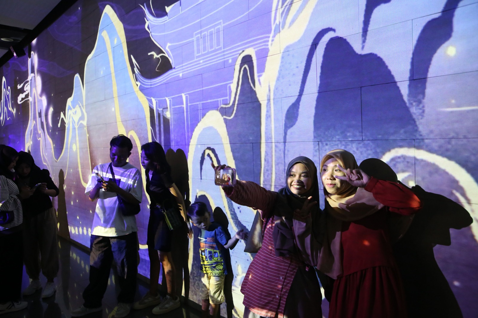 PERMAINAN CAHAYA: Pengunjung menikmati pameran video mapping di basement Alun-Alun Surabaya, Jalan Yos Sudarso, Surabaya.