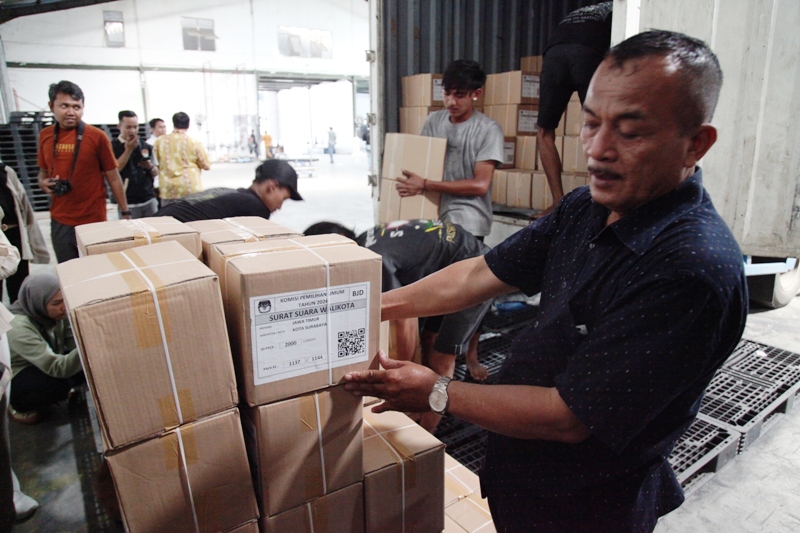 Pekerja menata kardus berisi surat suara Pilkada Surabaya 2024 di sebuah gudang di kawasan Margomulyo, Surabaya.