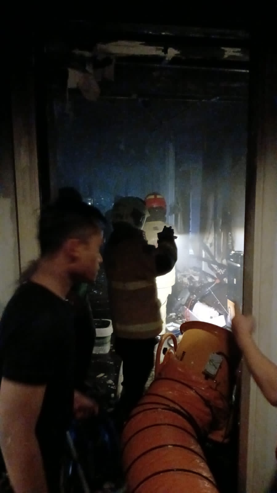 Petugas berusaha memadamkan kebakaran salah satu apartemen di Surabaya Barat. (IST)