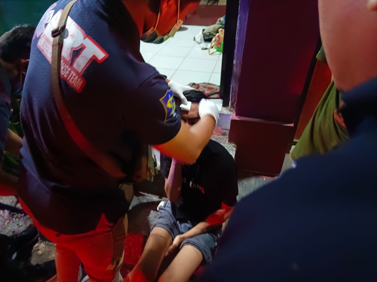 Petugas memberikan pertolongan pertama kepada ZMA, pemuda yang diduga menjadi korban pengeroyokan di Jalan Kendalsari Selatan, Surabaya.