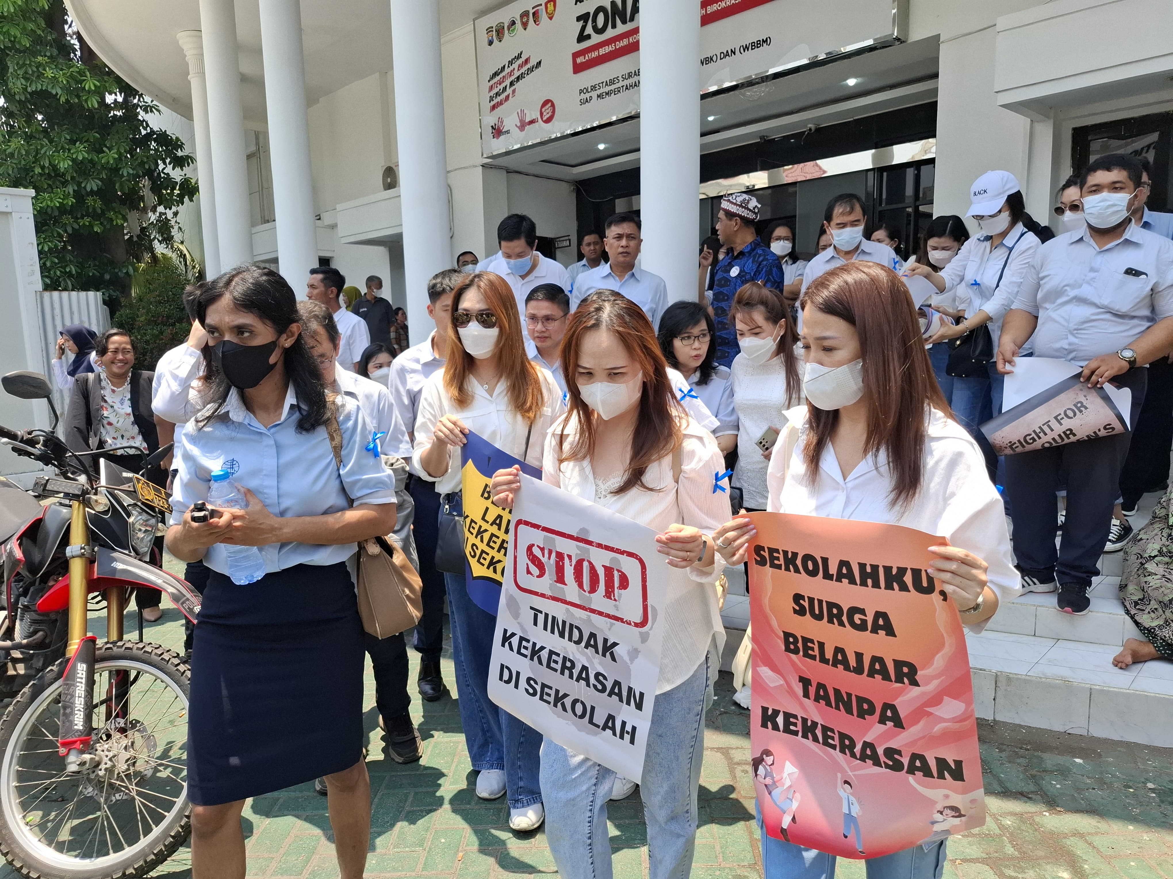 PULUHAN : Kepala sekolah dan guru SMA Gloria 2 Surabaya saat melaporkan aksi penggerudukan sekolahnya ke Mapolrestabes Surabaya.  &nbsp;