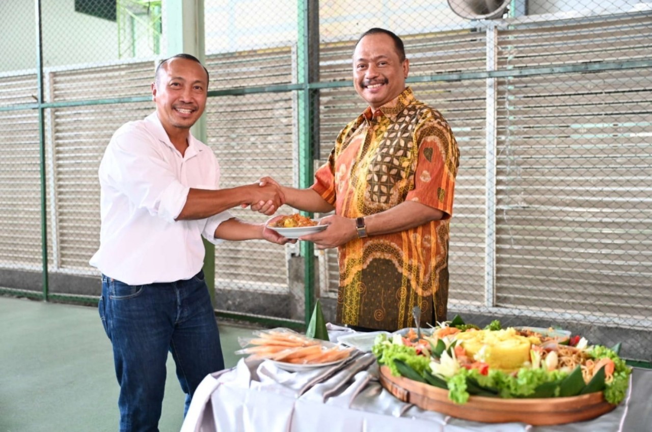 Ketua KONI Jatim M Nabil (kanan) memberikan potongan tumpeng kepada Direktur Badan Puslatda KONI Jatim, Dr Irmantara Subagio, M.Kes.