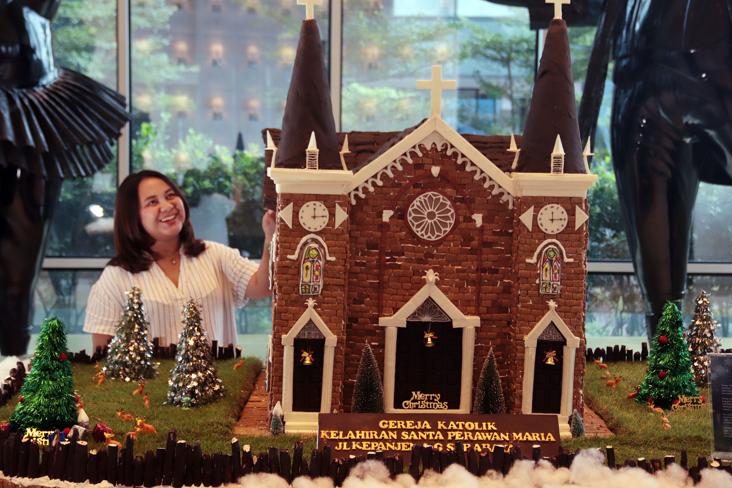 GEREJA COKLAT: Caroline mengamati miniatur gereja Katolik Kelahiran Santa Perawan Maria yang terbuat dari coklat, di lobi Ciputra World Hotel Surabaya, Senin (9/12).