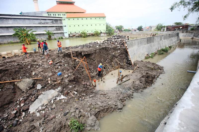 TOLAK BANJIR: Pekerja menyelesaikan pengerjaan saluran untuk menanggulangi banjir di kawasan Pakal Surabaya.