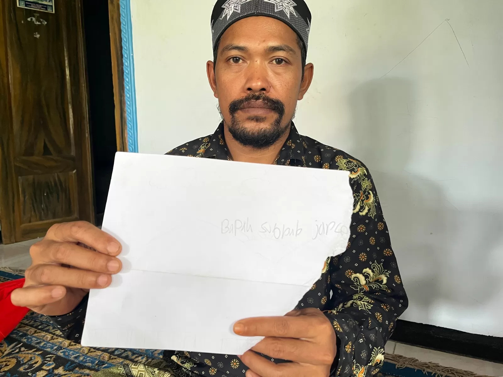 GURU DIPOLISIKAN MURID: Subhan, guru yang dipolisikan karena memukul muridnya dengan pipa kabel, menunjukkan bukti kertas milik siswa yang memakinya dengan kata kotor.