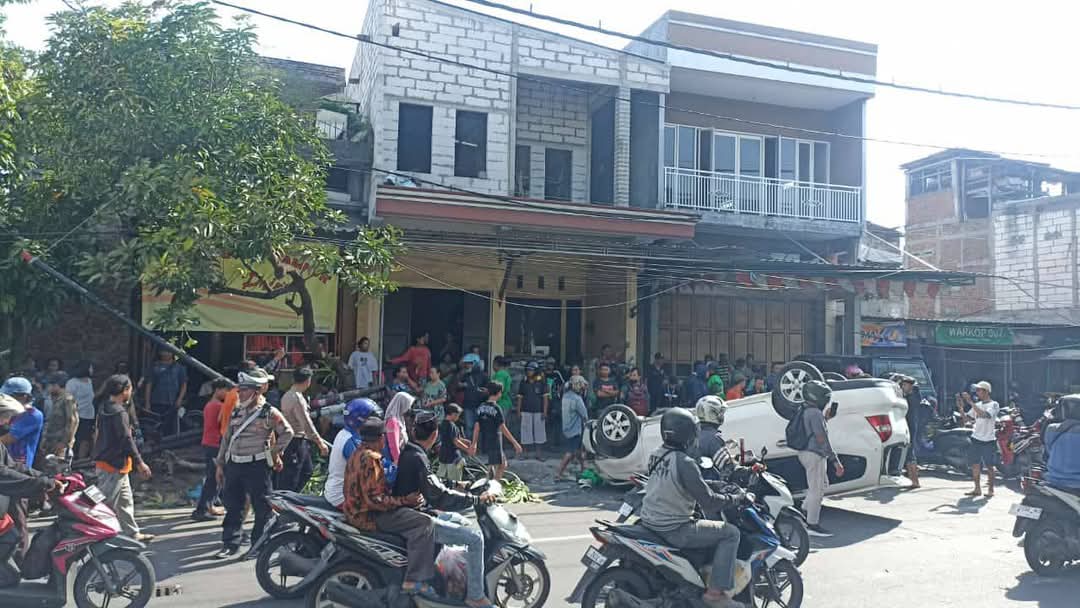 Sebuah mobil Nissan Gran Livina  warna putih menabrak motor dan tiang listrik di Jalan Raya Tandes Lor Karangpoh, Tandes, Surabaya, Kamis sore (19/12).  (IST)