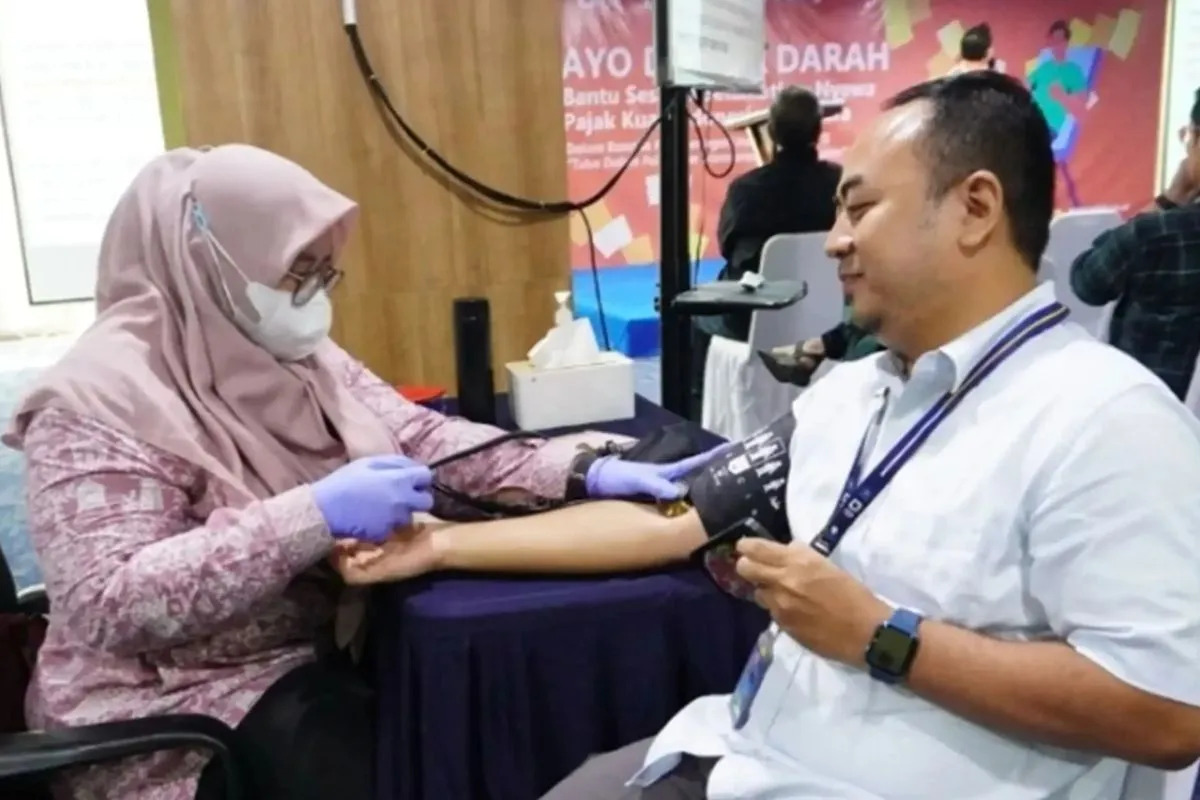 Petugas kesehatan mengukur tekanan darah pasien.