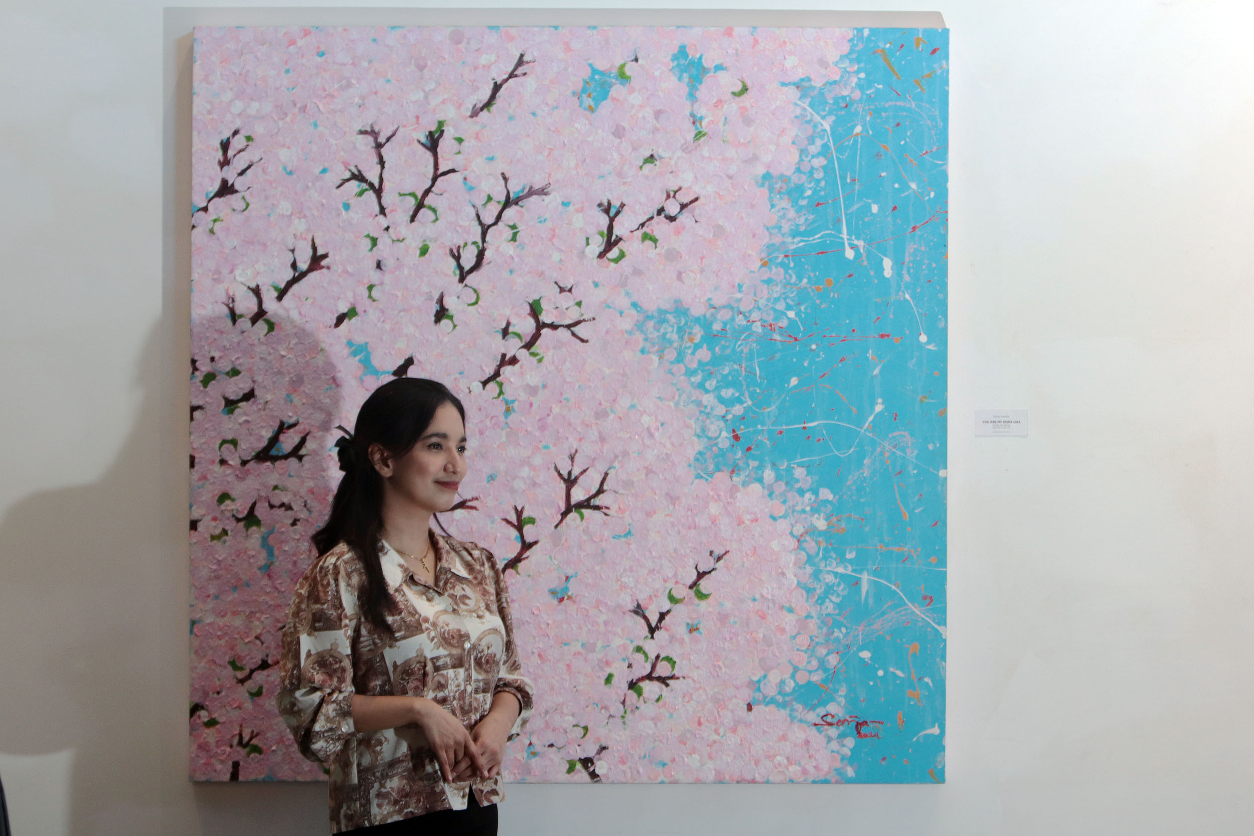 LUKISAN MUSIM SEMI: Karina, mengamati lukisan-lukisan karya perupa Sonja Irawaty yang bertajuk Life, Love & Cherry Blossom di Artspace, Artotel TS Suites Surabaya.