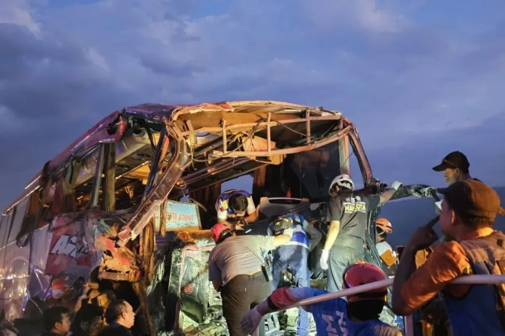 Petugas mengevakuasi bus yang mengalami kecelakaan di Kilometer 77+200 Jalan Tol Pandaan-Malang, Jawa Timur, Senin (23/12).